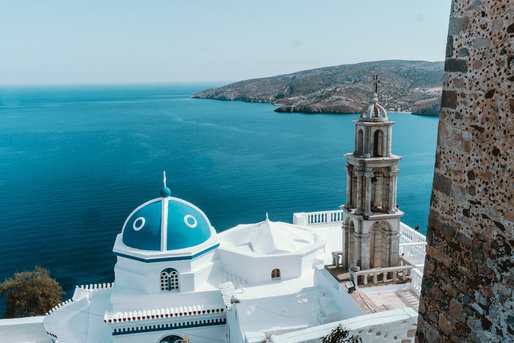 a white building with a blue ocean in the background