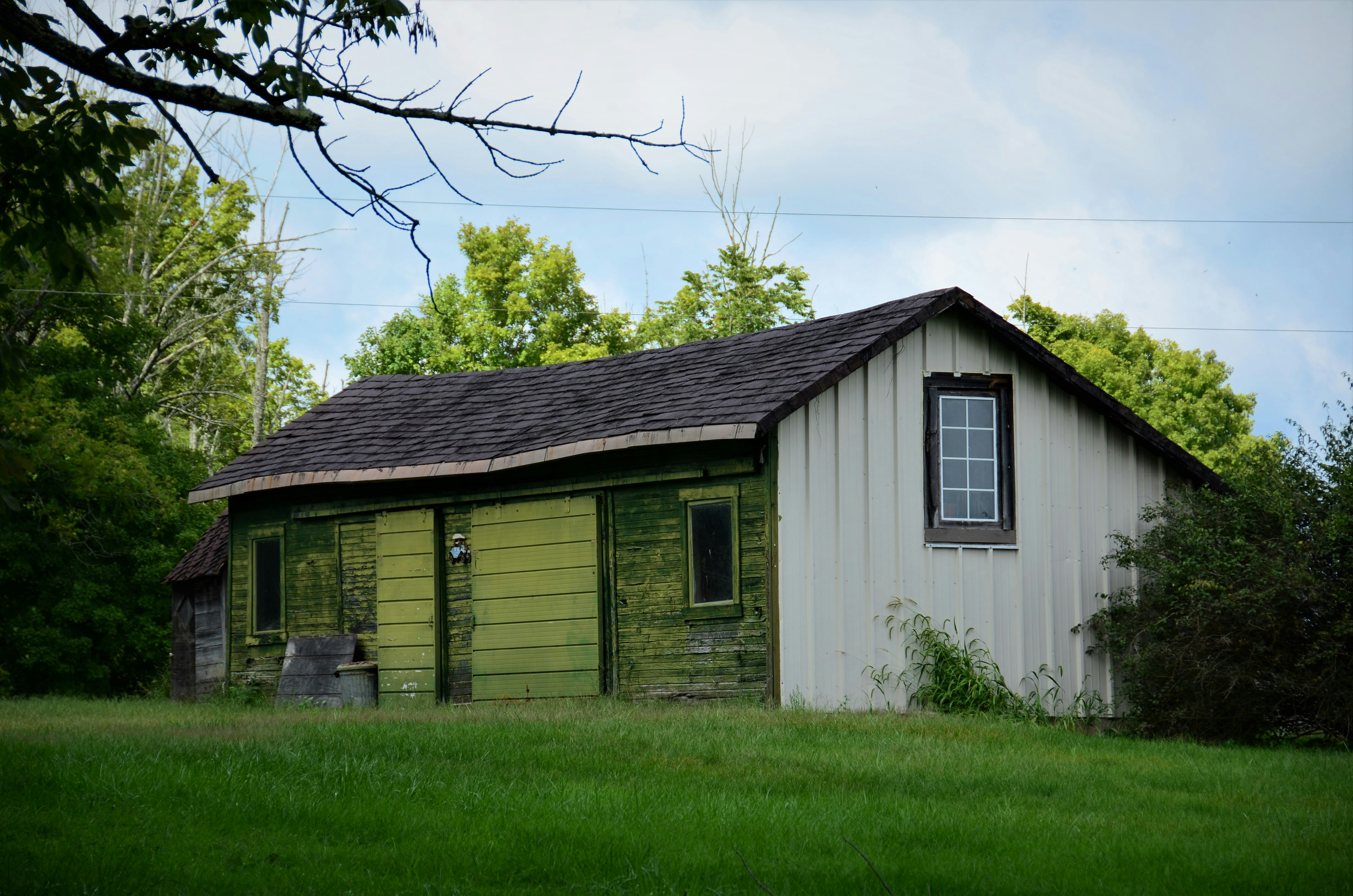 Old white farm shed with green front