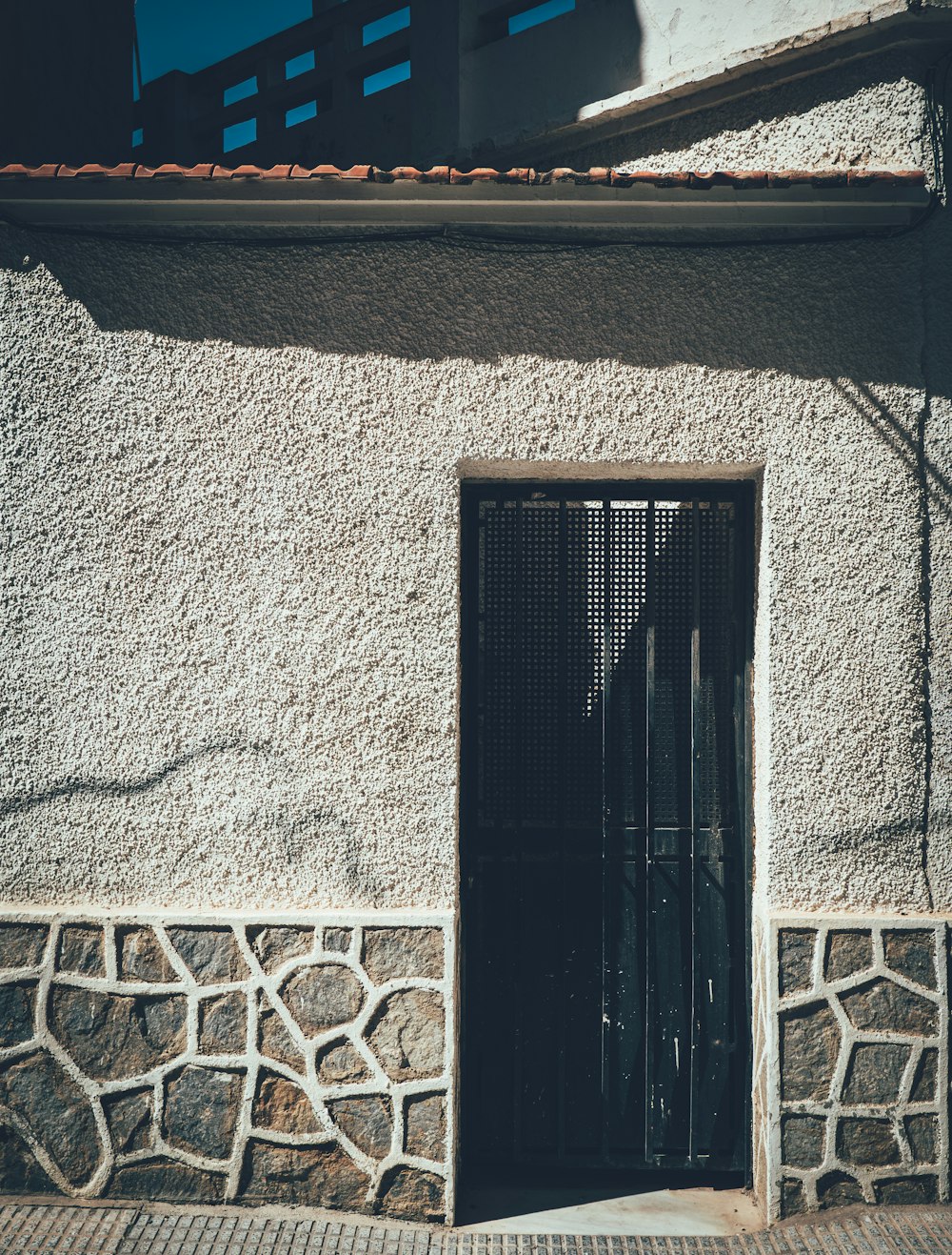 uma porta preta em um edifício de pedra