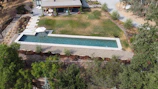 An aerial view of a spacious backyard showcasing a newly constructed luxury pool and outdoor living area.