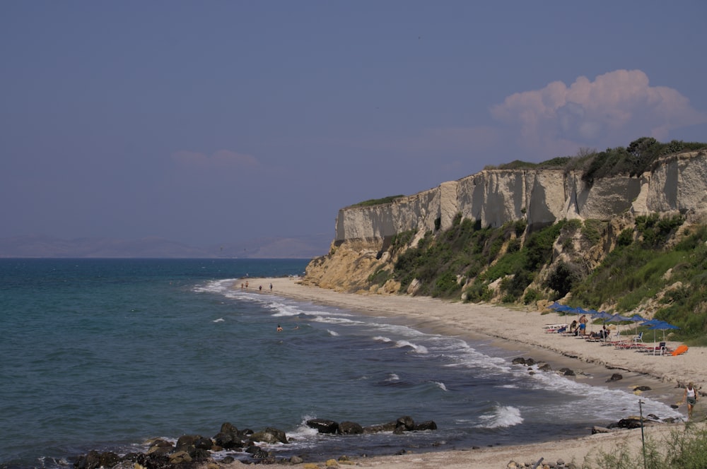 a beach with a cliff and water