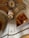 An ornate architectural interior features an intricately decorated ceiling with gold and patterns. A vintage chandelier hangs prominently, casting a warm glow over the marble archways and detailed moldings. The overall design reflects a classic and grand style.