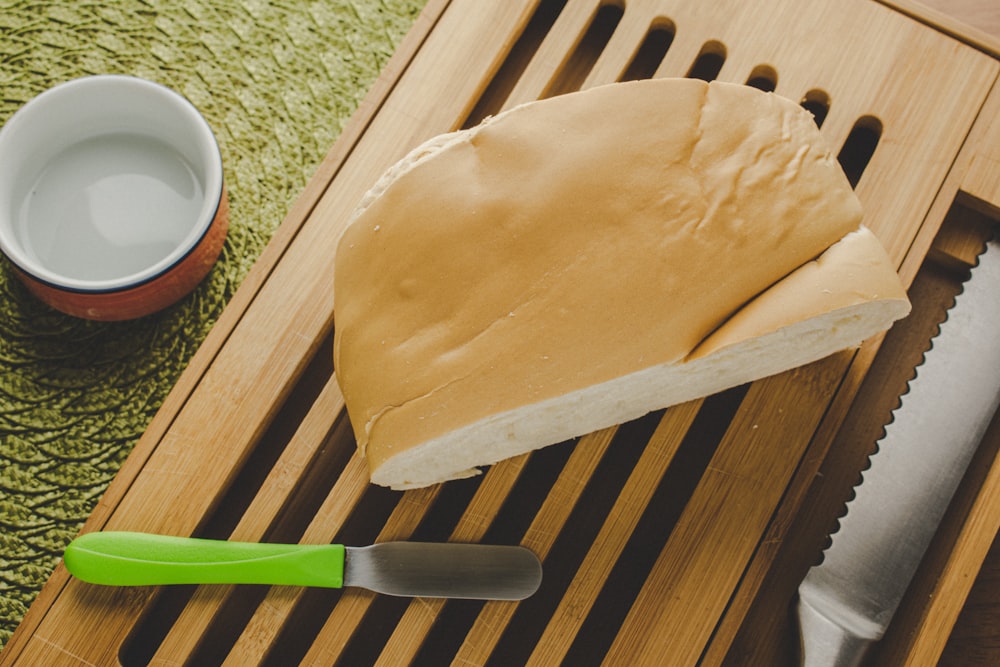 a wooden board with a knife and a bowl of food