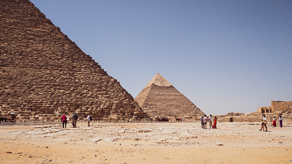 a group of people standing in front of a group of pyramids