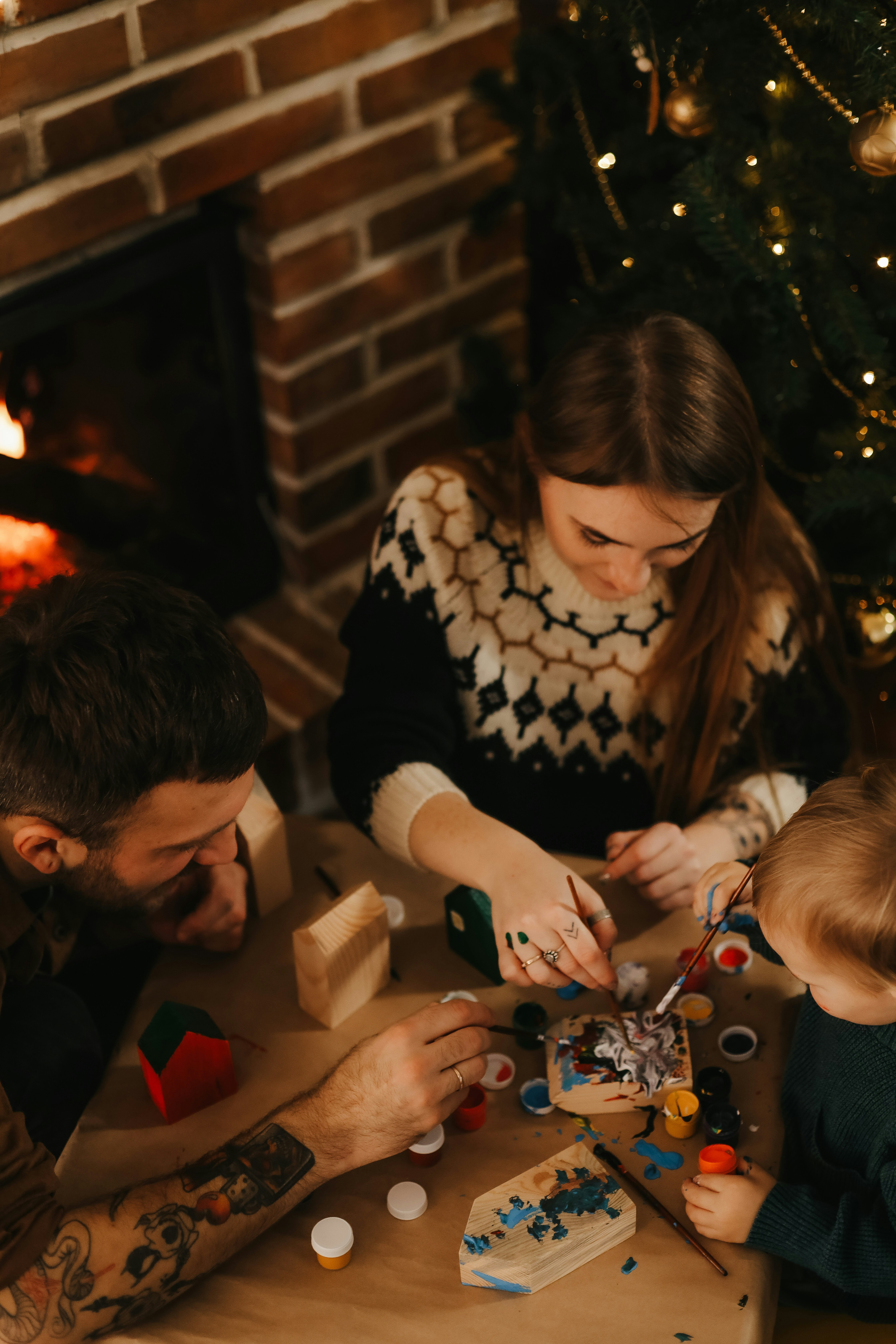 a man and a woman playing with toys in front of a christmas tree