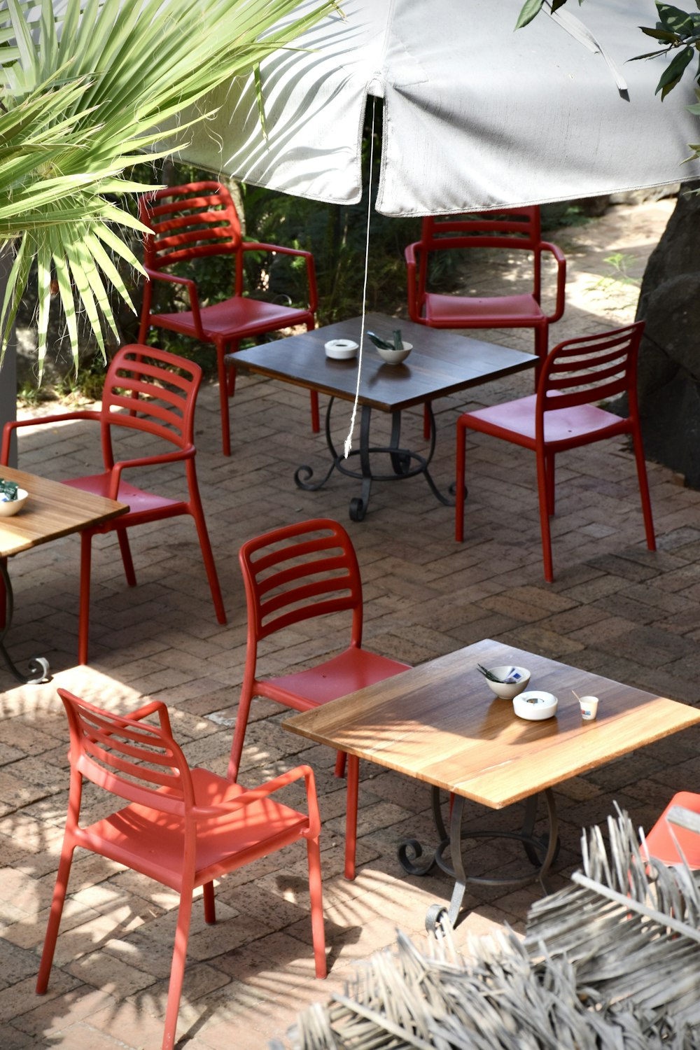 a group of tables and chairs under an umbrella