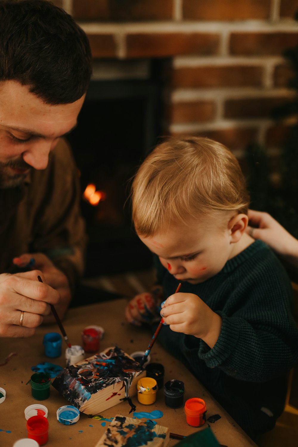 a person and a child playing with toys on a table