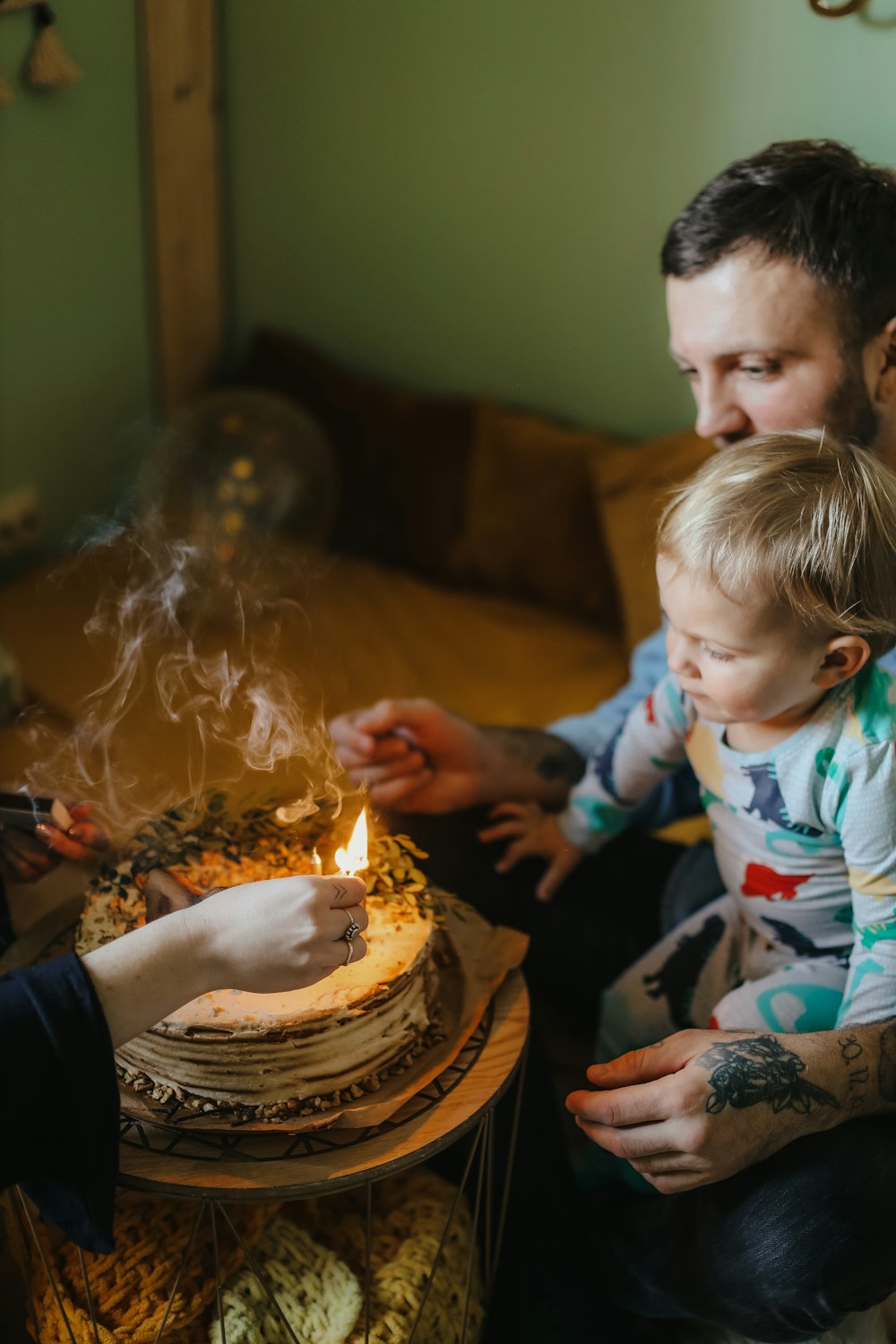 a person and a child blowing out candles on a cake