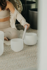 a person pouring a liquid into a white cup