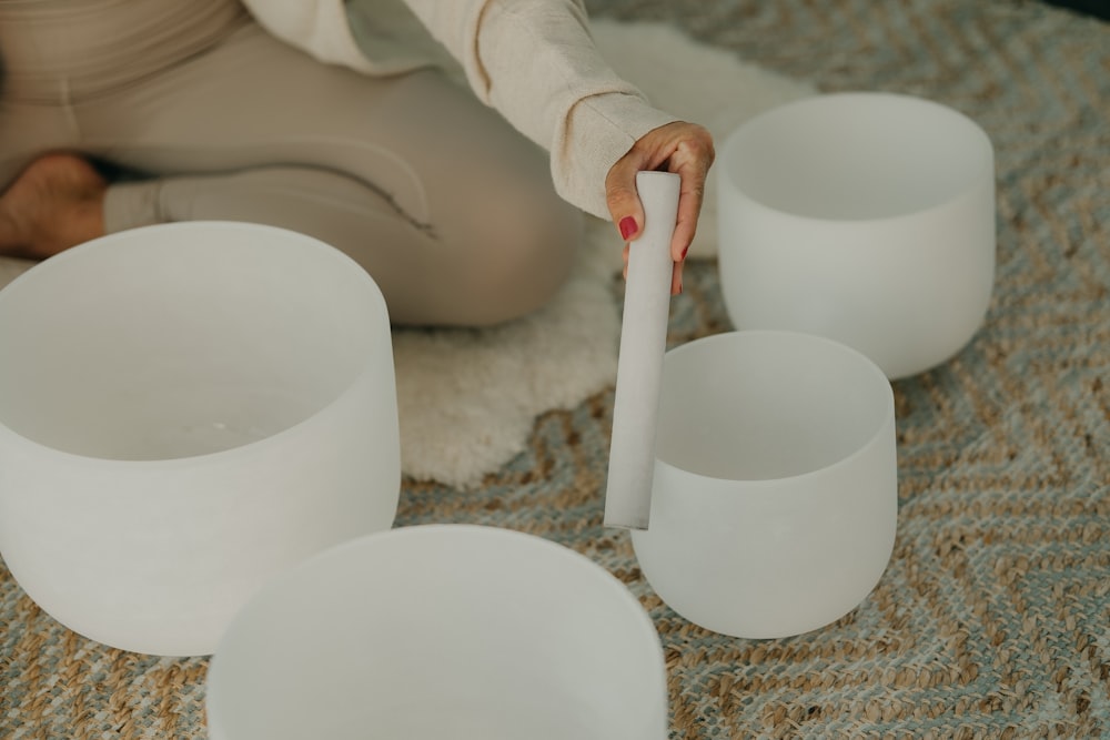 a person pouring a liquid into a white cup