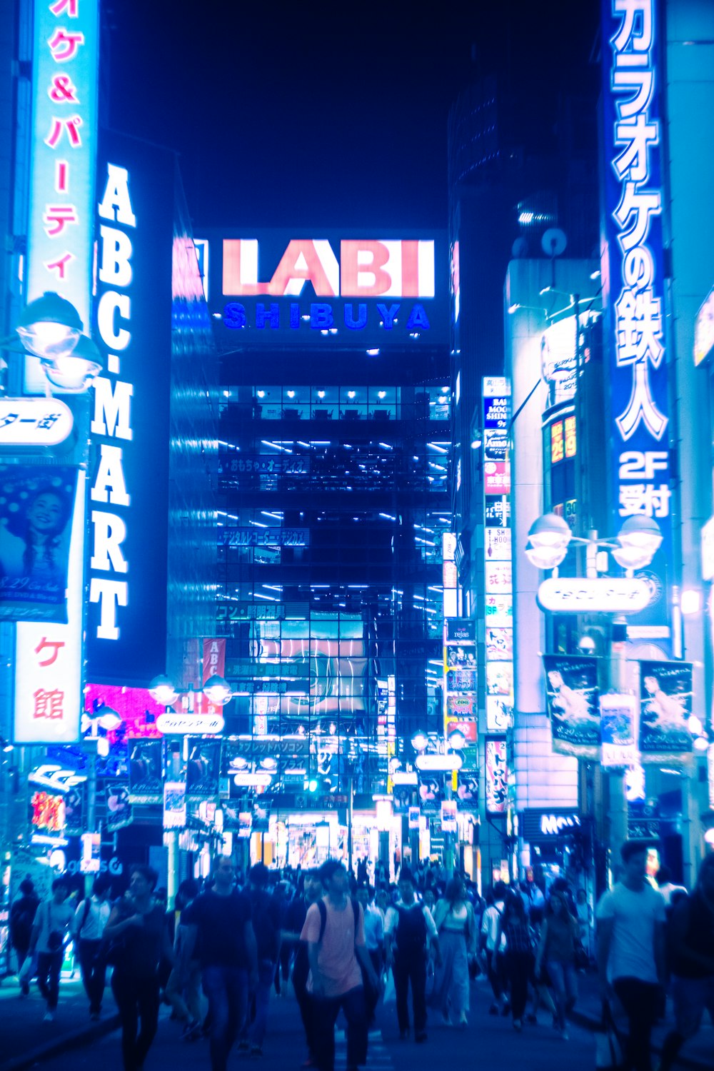 Un grupo de personas caminando en una ciudad por la noche