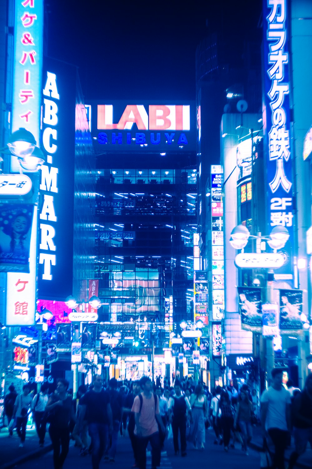 a group of people walking in a city at night