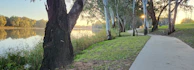 A peaceful riverside path in Saint-Priest lined with trees and benches inviting a stroll.