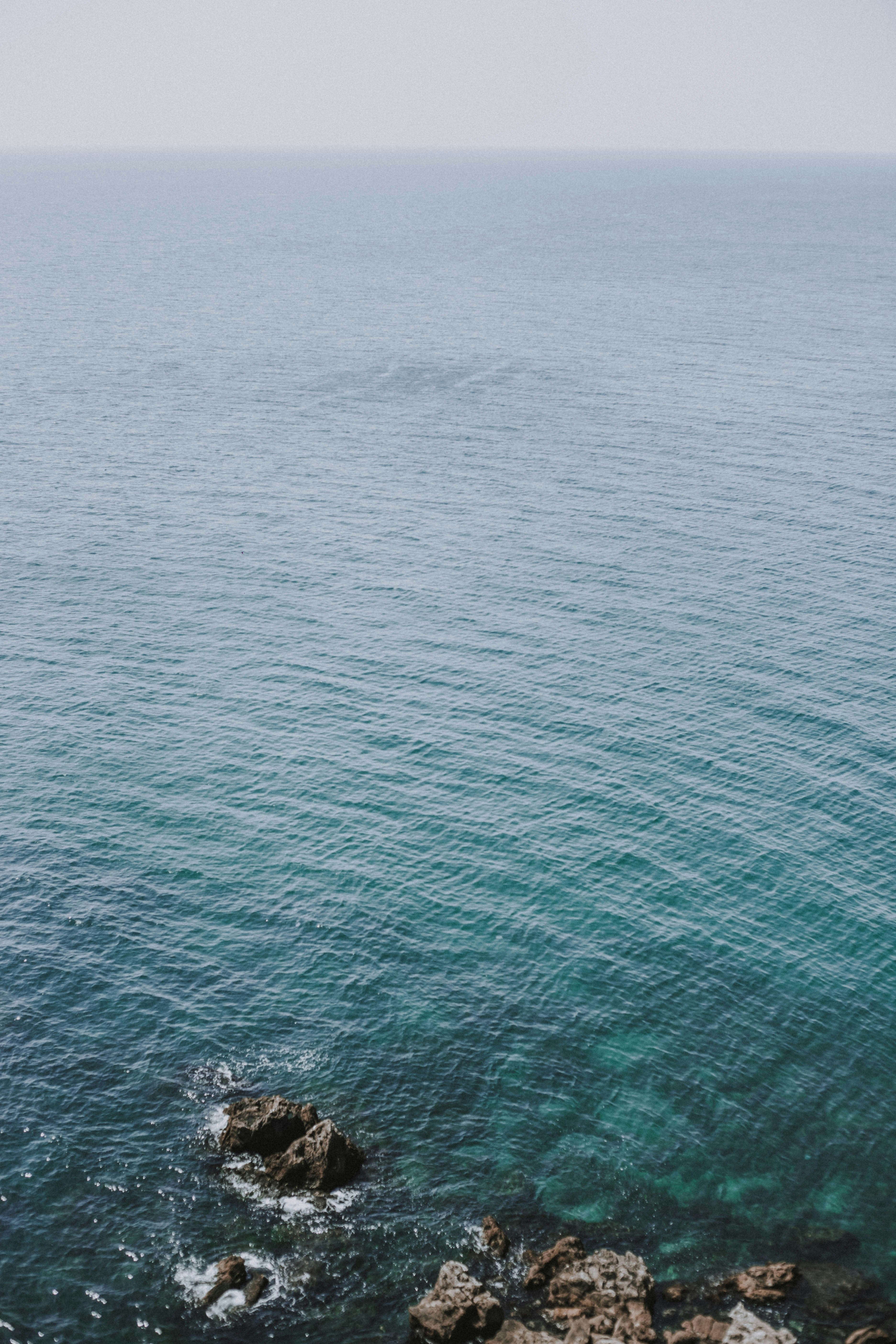 a body of water with rocks and a beach