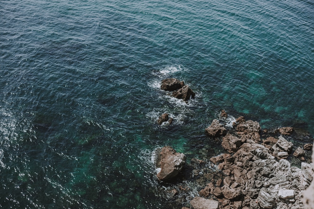 a rocky shore with water and blue sky