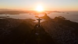 View of the iconic Christ the Redeemer statue overlooking the city and bay at sunset.