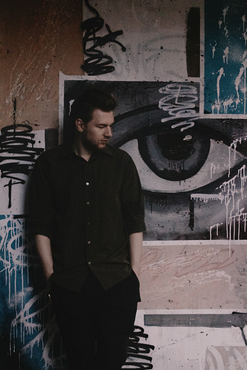 a man standing in front of a wall with graffiti