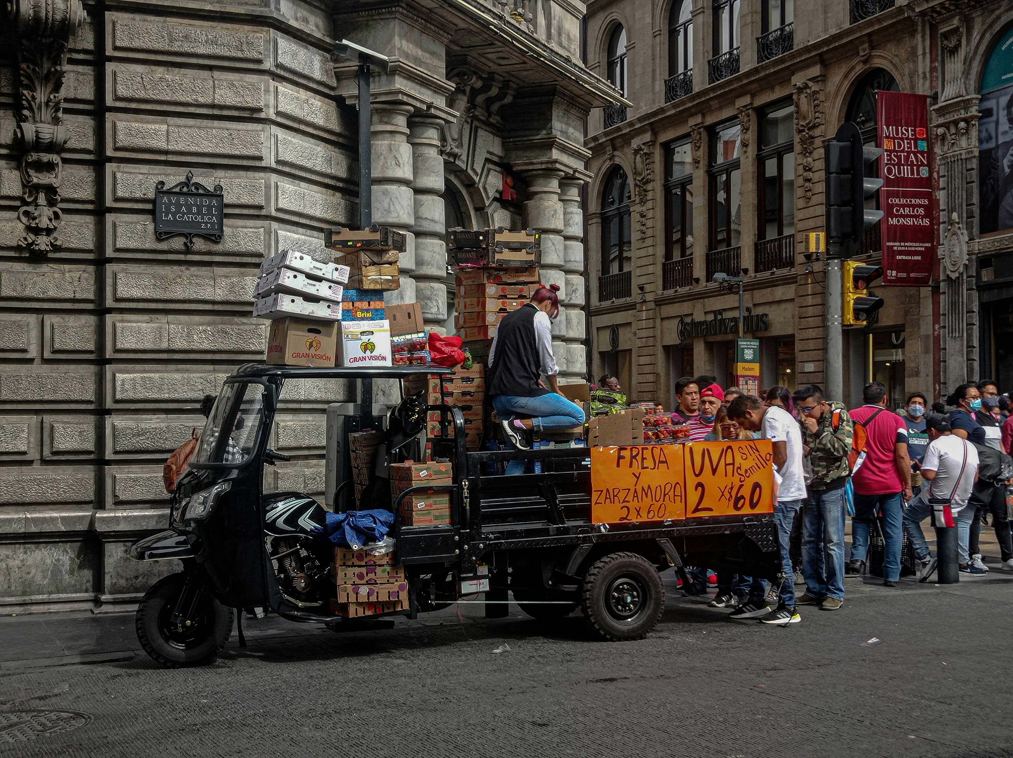 a person on a motorcycle with a cart full of boxes