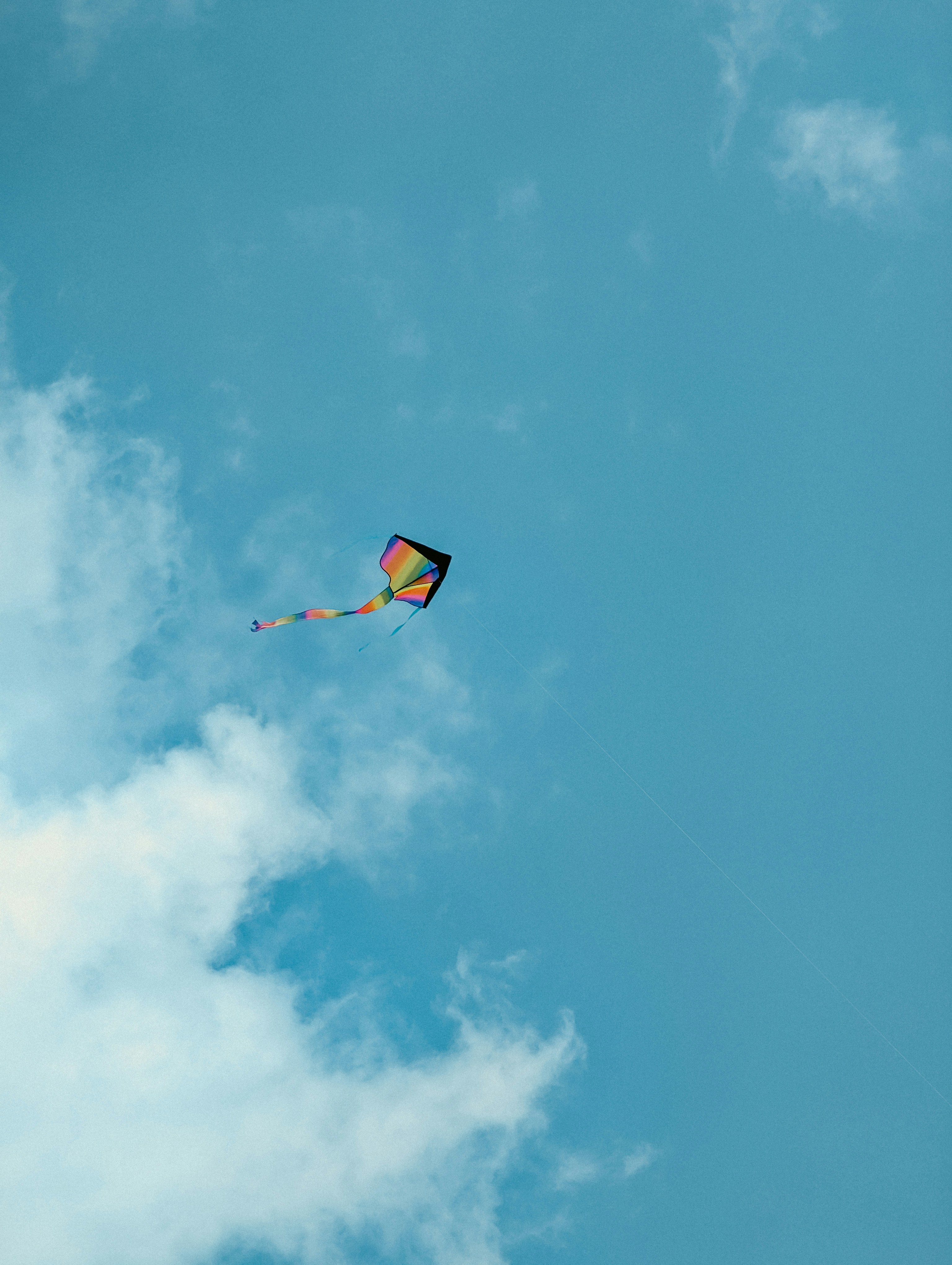 Rainbow kite with a background of a blue sky.