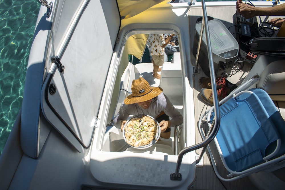 a person in a hat holding a bowl of popcorn