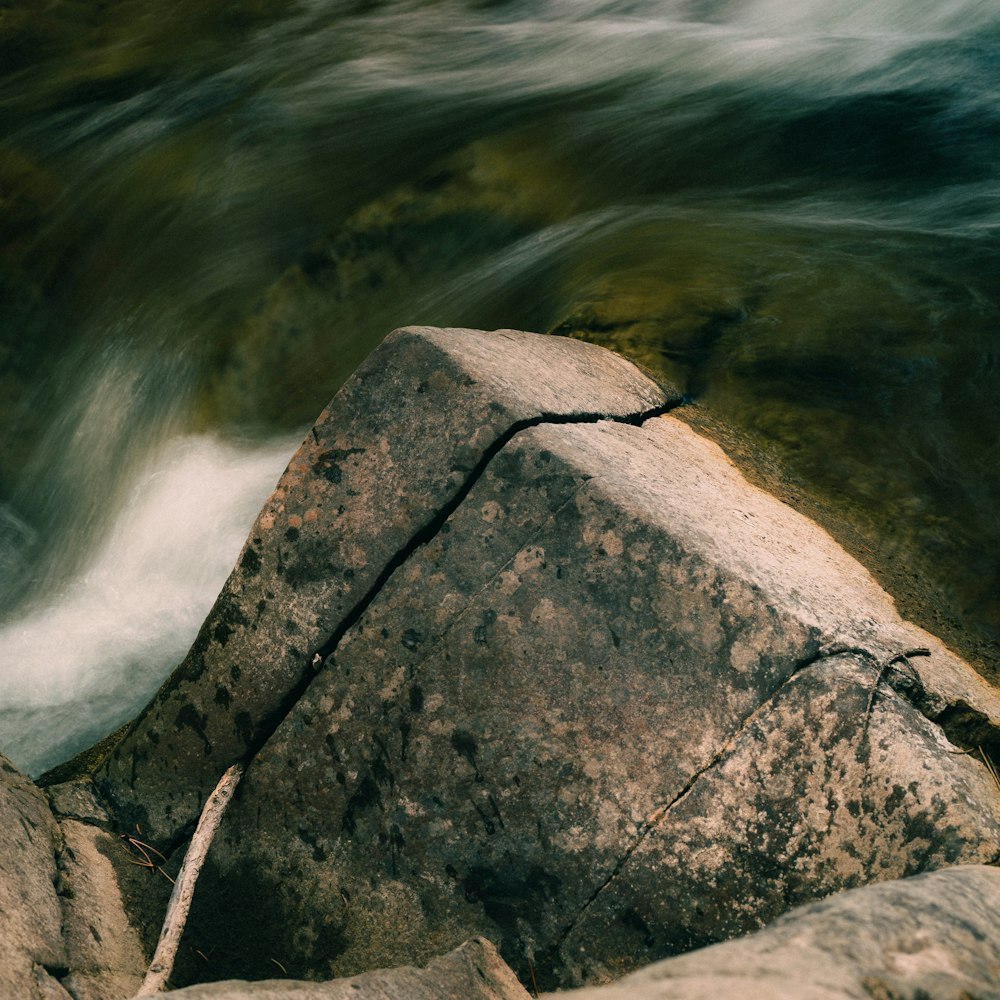 a large rock with a waterfall