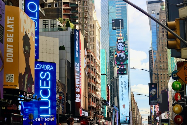 A vibrant city street with large, eye-catching billboard advertisements at busy intersections.