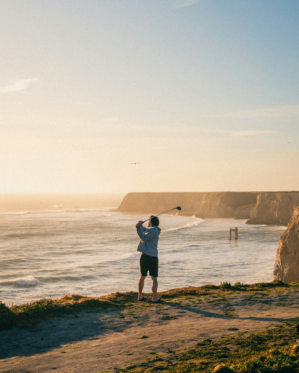 a man holding a fishing pole on a beach