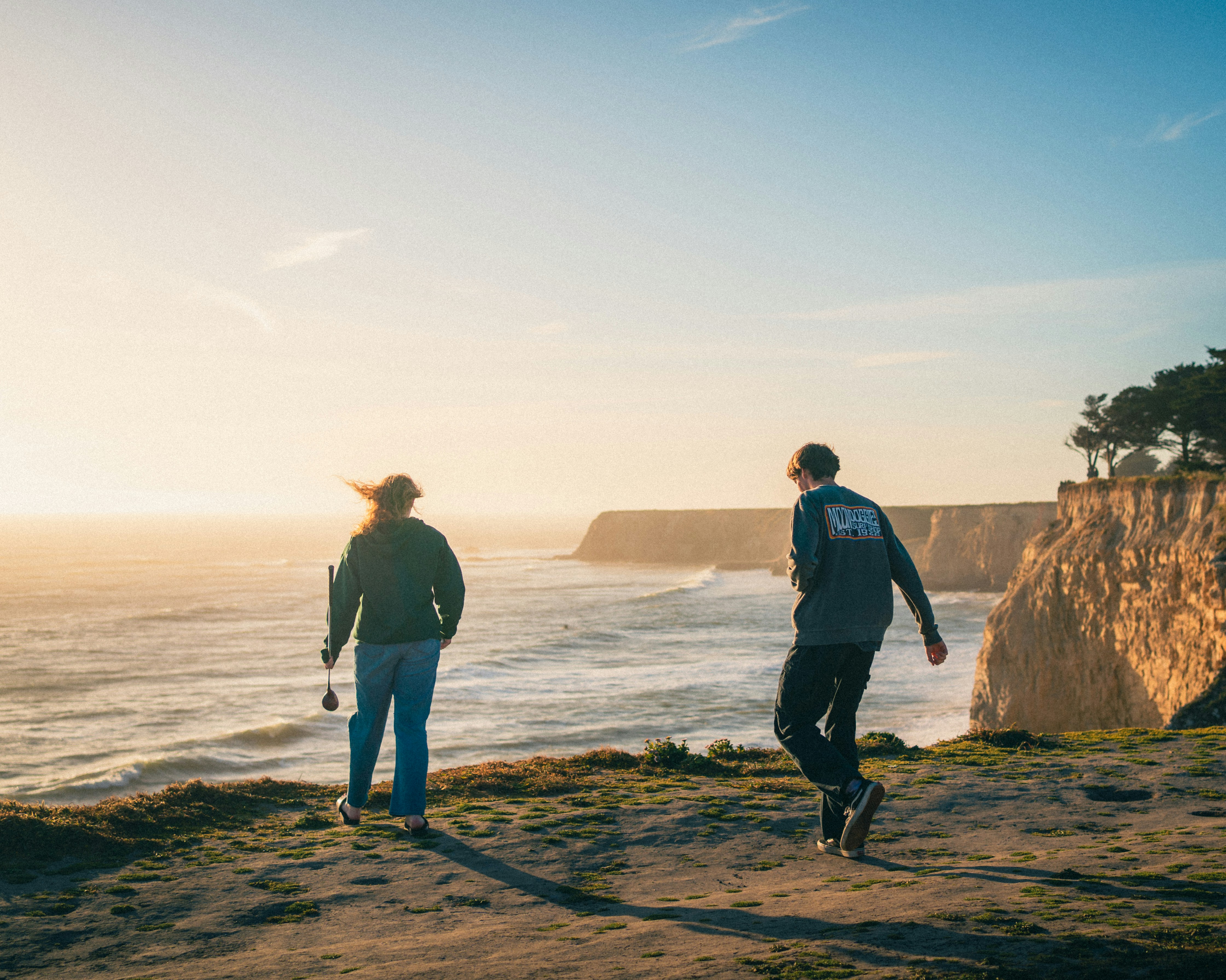 a man and woman walking on a beach