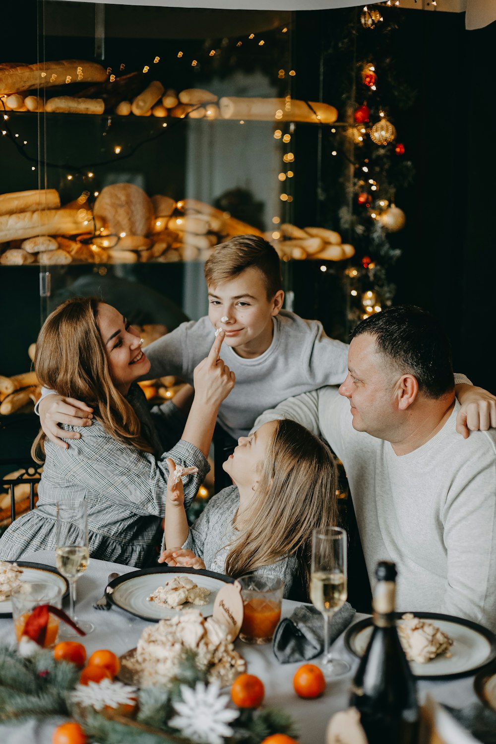 a group of people sitting at a table with food and drinks