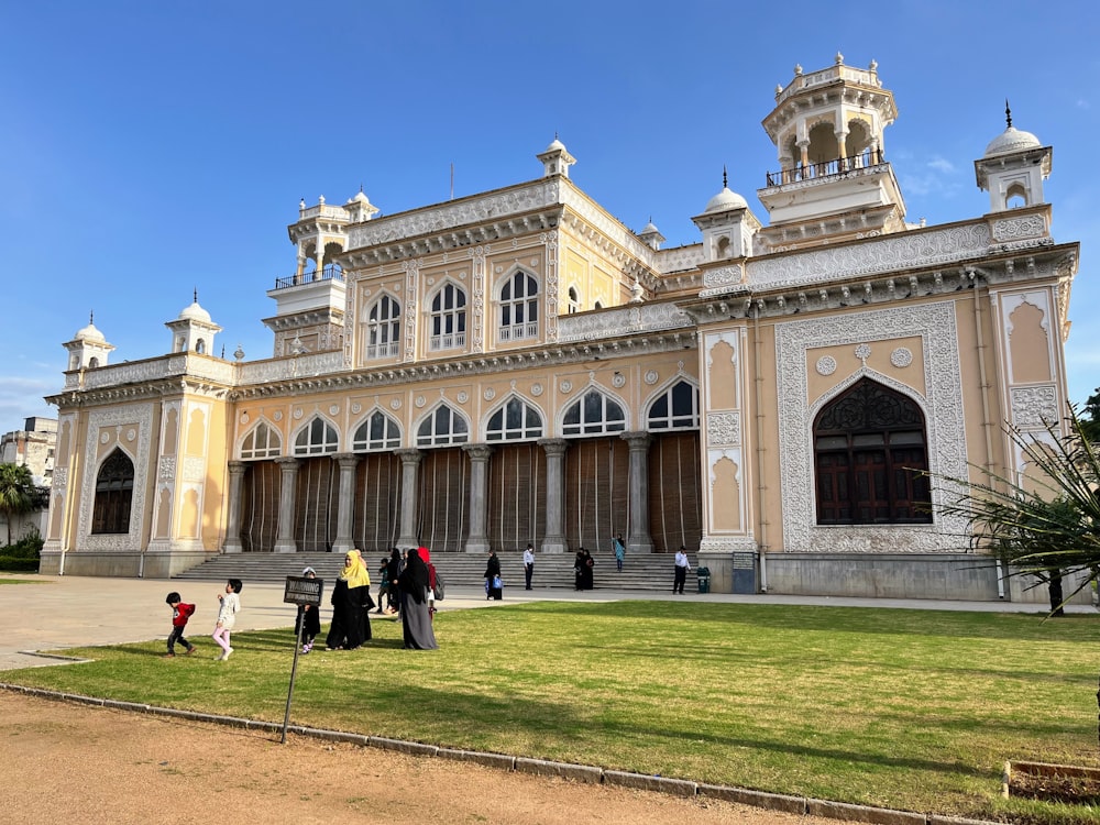 a large building with people walking around with Chowmahalla Palace in the background