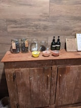 A cozy homestead kitchen with jars of crafted soaps and natural ingredients on shelves.