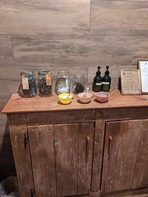 A cozy corner of the homestead kitchen with jars of herbal remedies and natural soaps on wooden shelves