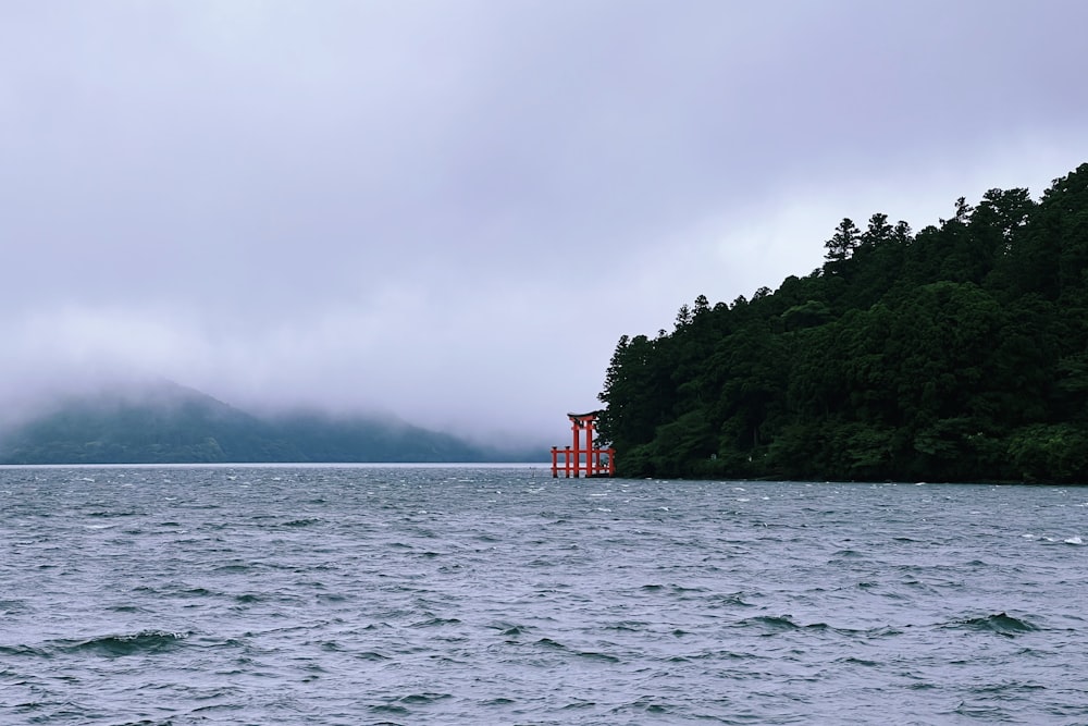 a red structure in the middle of a body of water