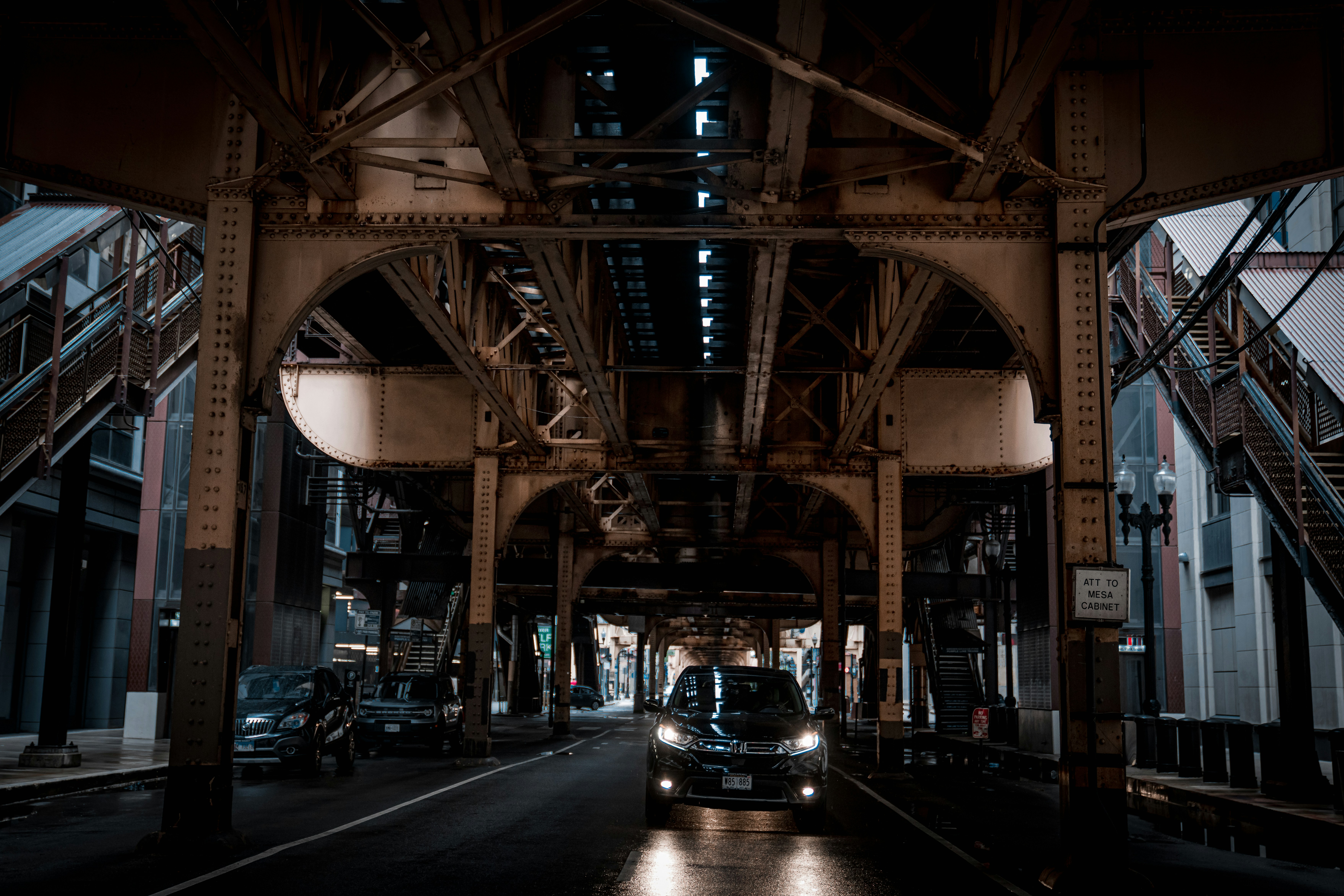 cars driving under a bridge