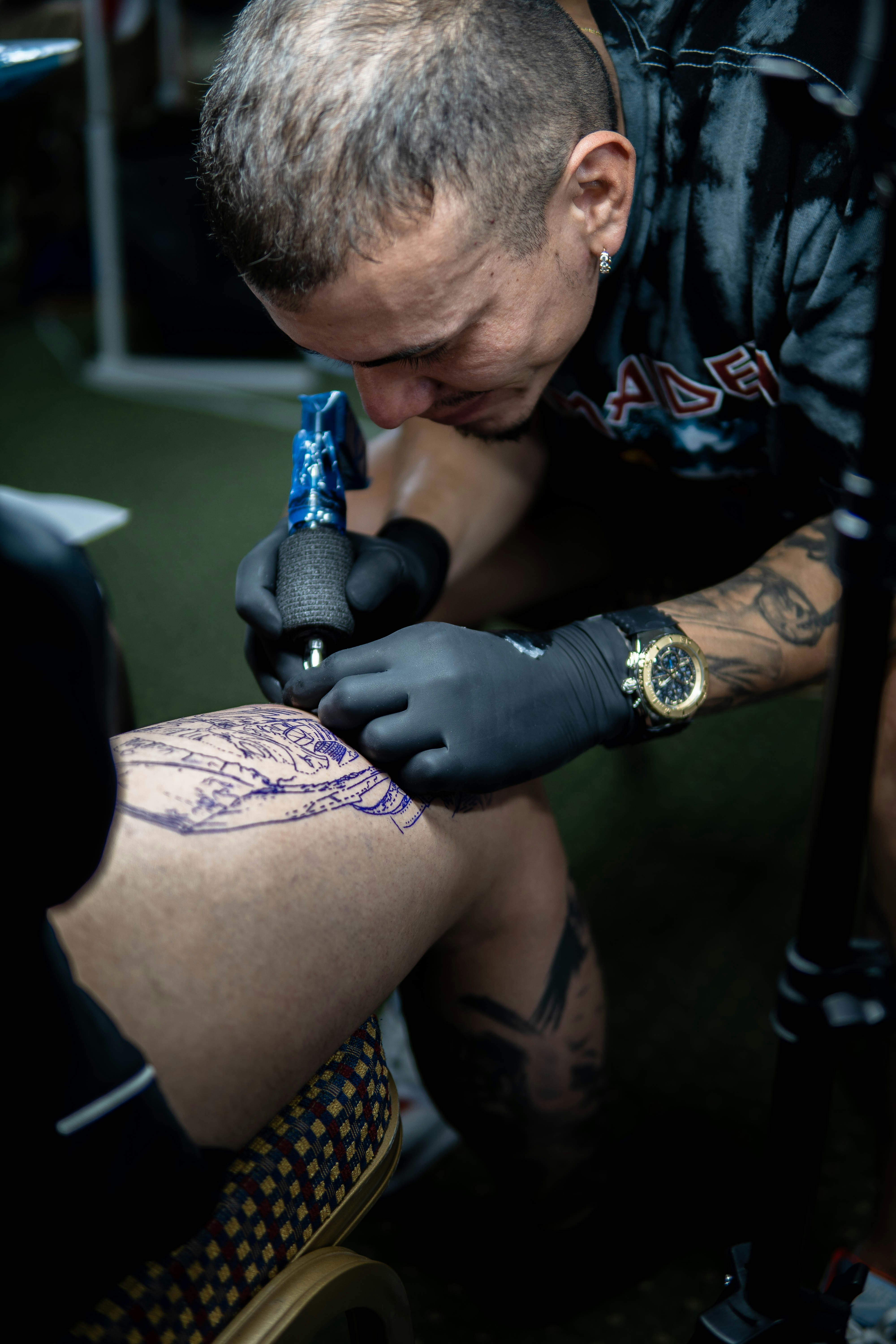 Un uomo con tatuaggi che tengono un trapano