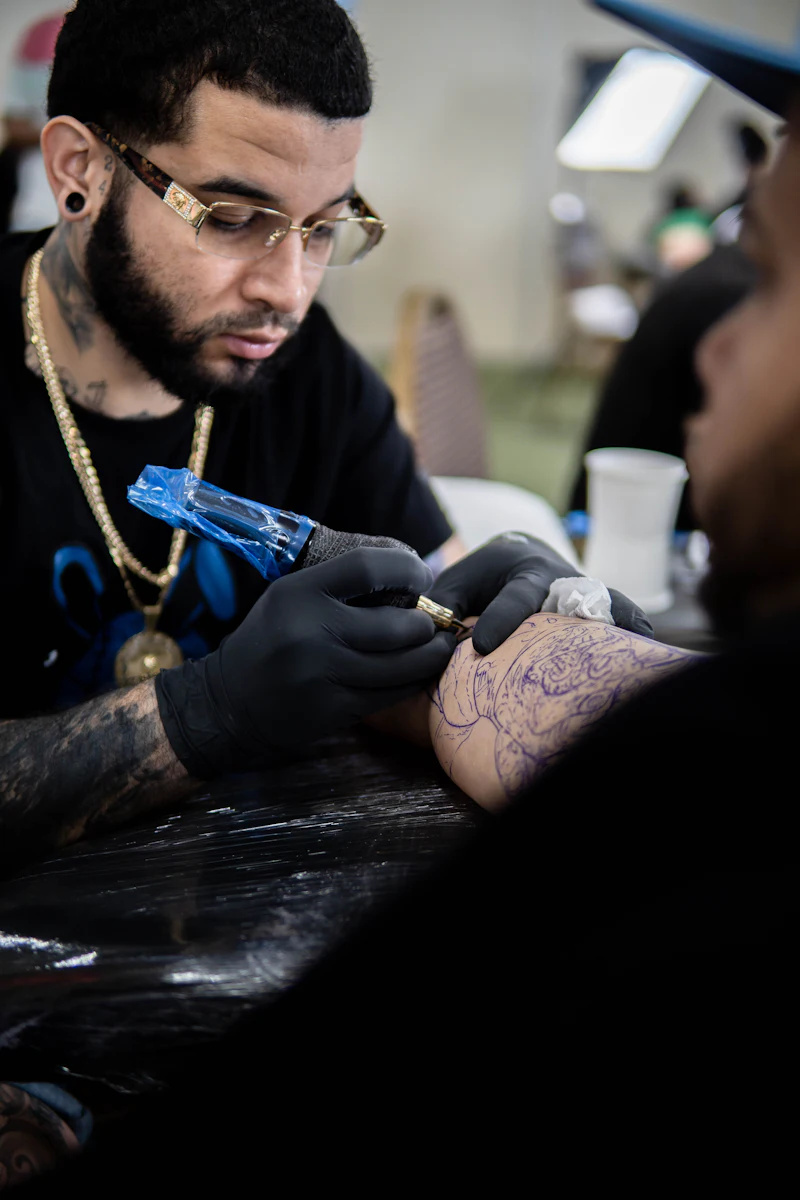 An artist tattooing an arm