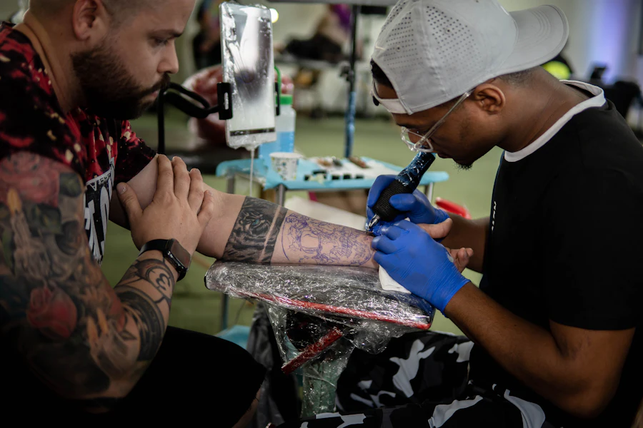 Tatuador concentrado trabalhando no braço de um cliente