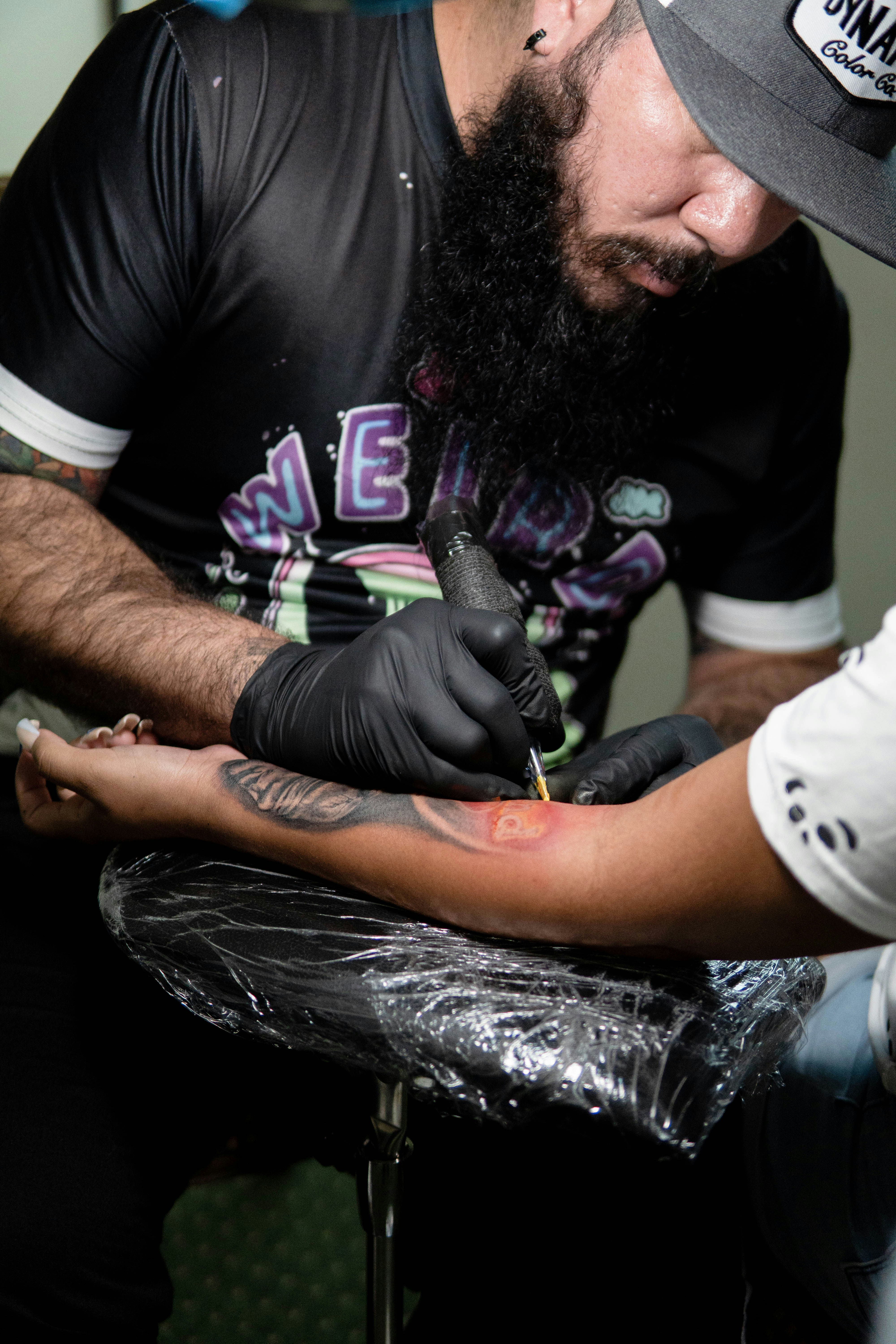 a man with a beard holding a tattoo on his arm
