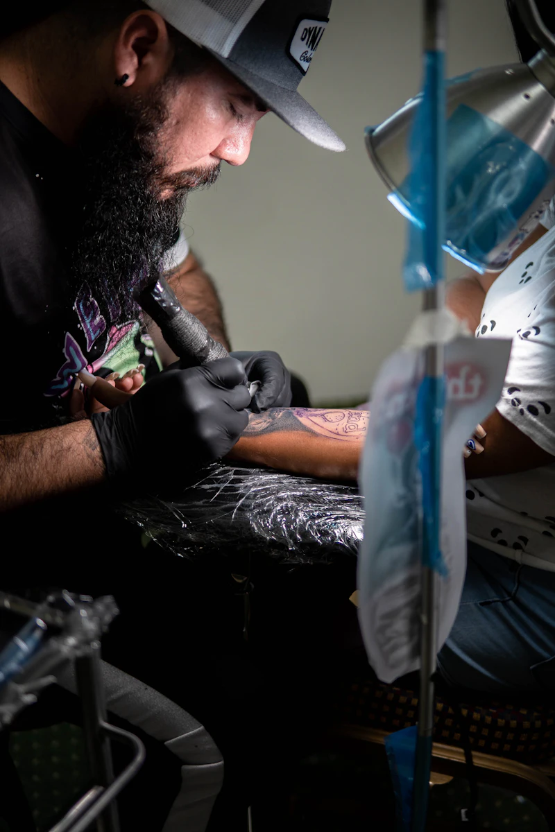 A tattoo artist concentrating on a piece