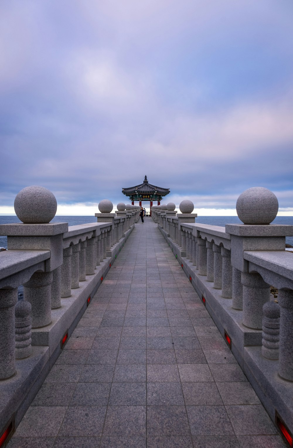 a stone walkway with a structure on the side