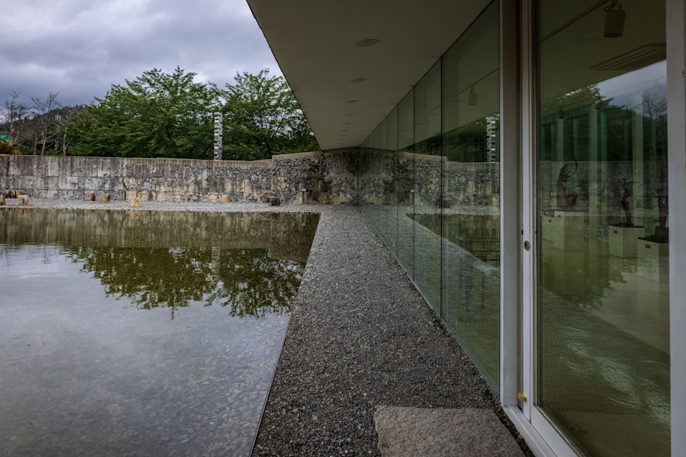 a building with glass walls and a pond