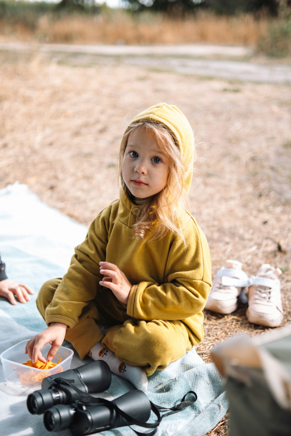 a person sitting on a blanket outside