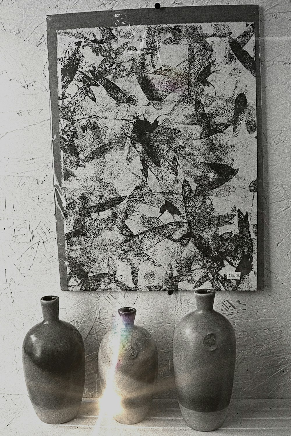 um grupo de vasos sentados em frente a uma pintura