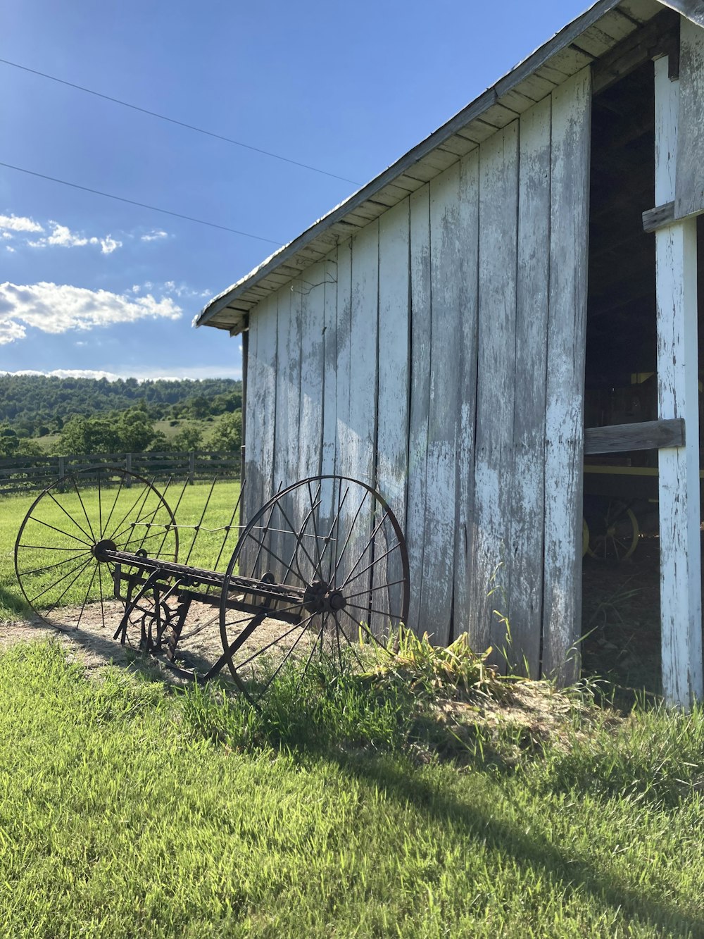 a wooden building with a wheelbarrow in front of it