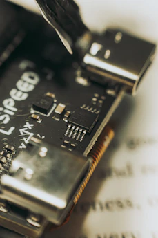 Compact microcontroller units with visible pins and ports, illuminated softly in a dark tech setting.