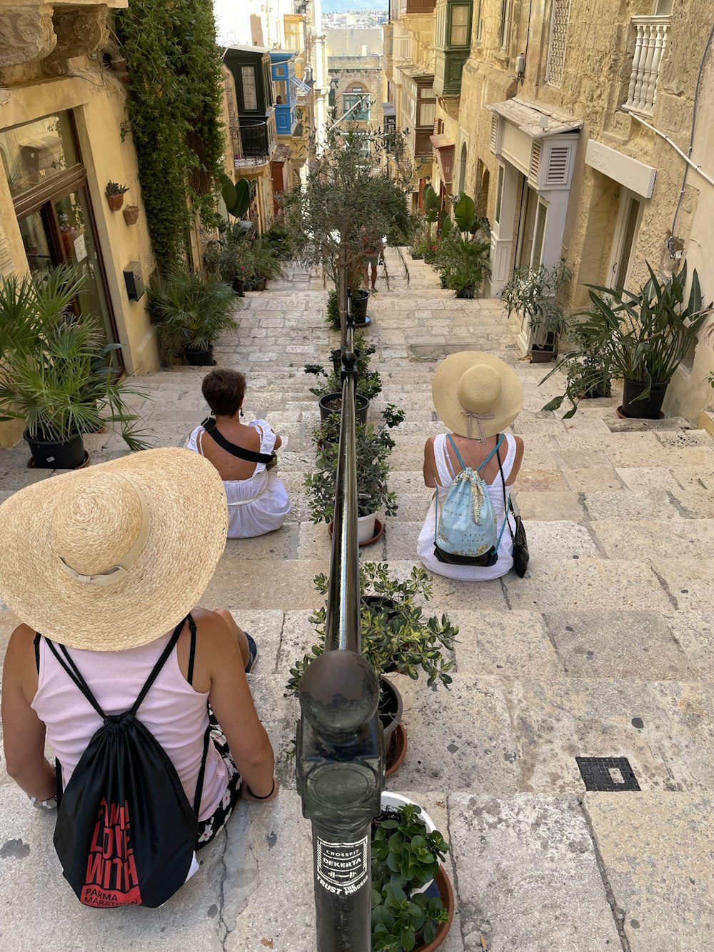 a group of women sitting on a sidewalk