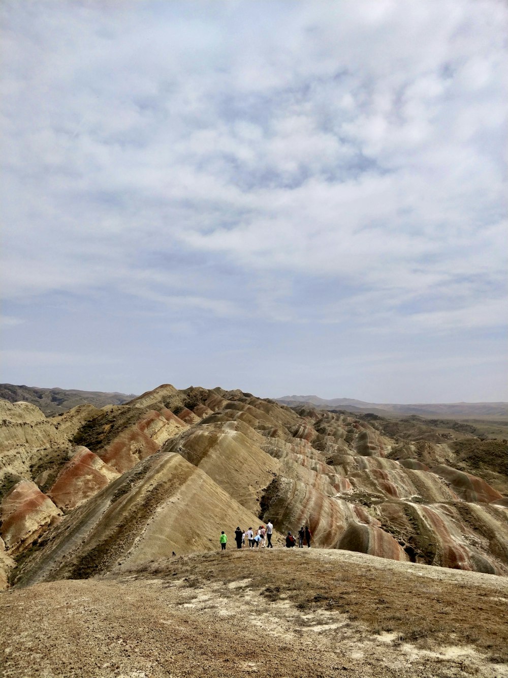 a group of people walking on a rocky hill