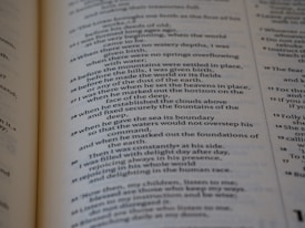 A close-up of a page from a book written in verse format, containing numbered lines of text. The text is organized in a poetic style, with a clear structure and alignment.