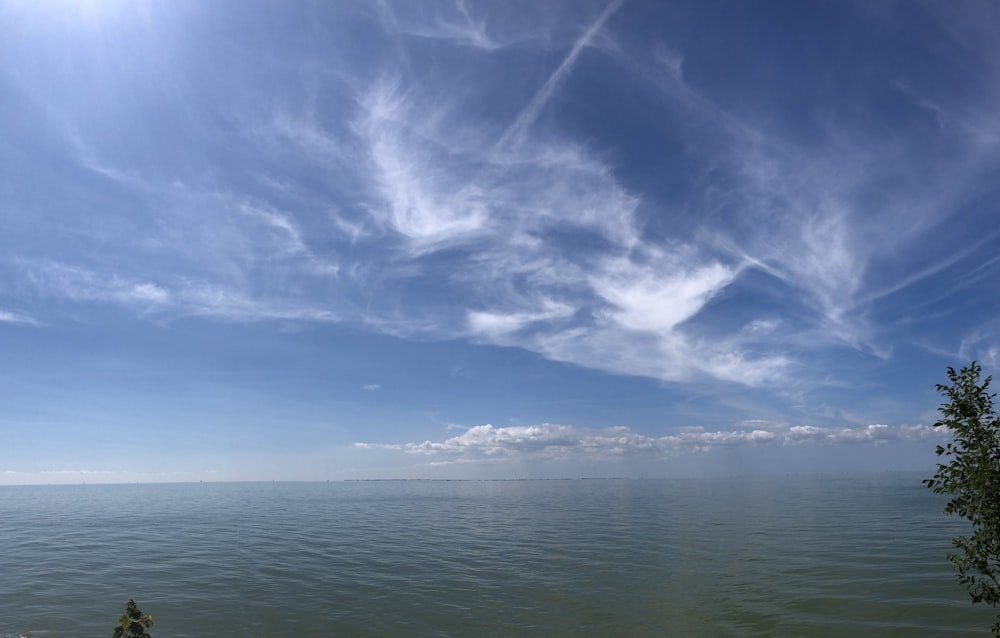 a body of water with clouds above it