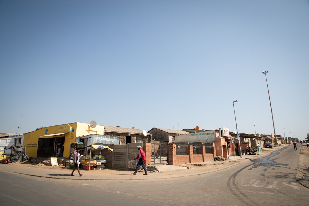 a group of people walking on a street next to a building